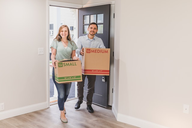 two tenant carrying moving boxed into their new unfurnished property